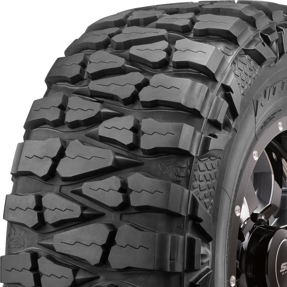 Mud-terrain tire with deep blocky lugs wrapping over the shoulder onto the sidewall, mounted on a black off-road wheel
